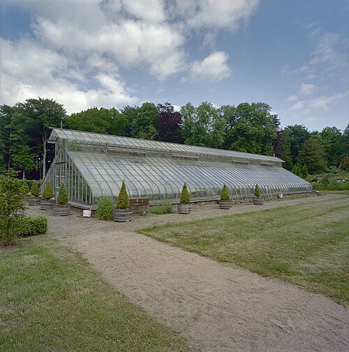 Traubenhaus (druivenkas) von Oud Groevenbeek, Ermelo, Gelderland — Oud Groevenbeek: Overzicht van de kas met toegangsdeur en lantaarn en kuipplanten rondom…